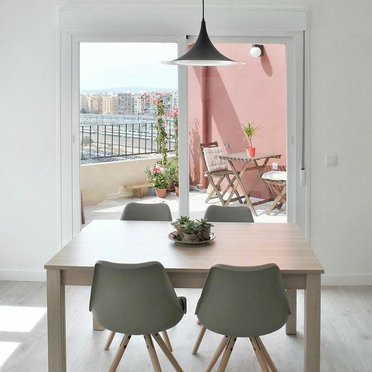 sparse modern room dining table and four chairs city view